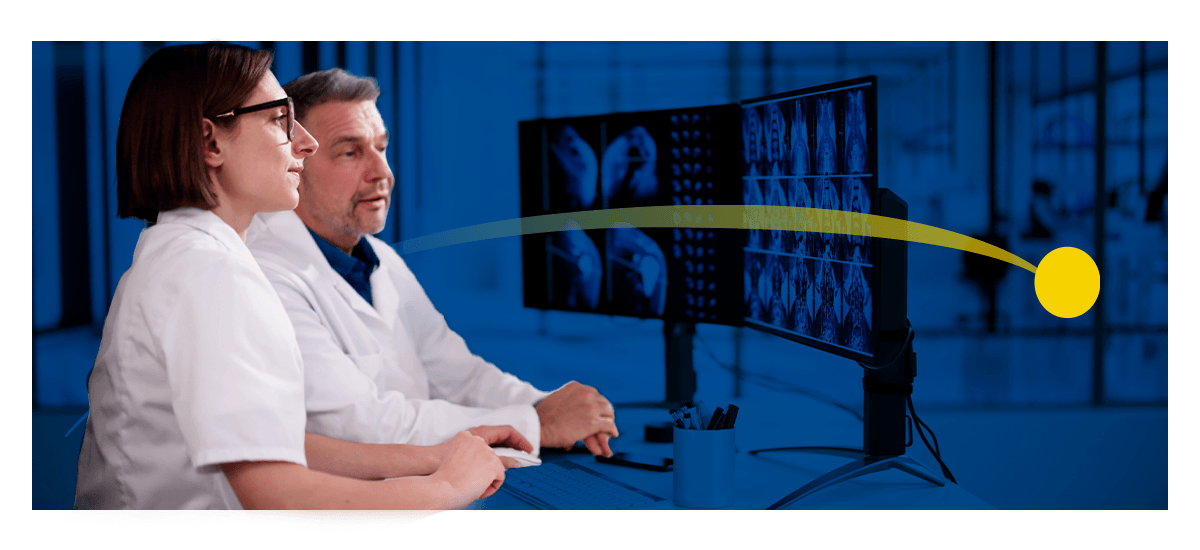A male and female radiologist look over scans